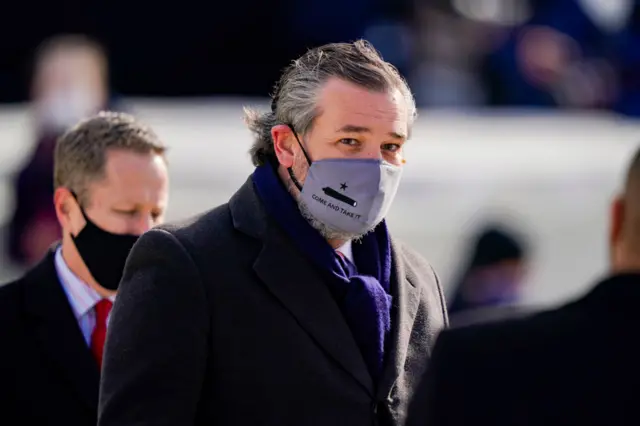 Sen. Ted Cruz (C) (R-TX), wearing a face mask that reads "Come and Take It", arrives to the inauguration