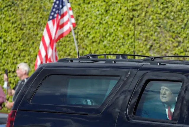 U.S. President Donald Trump reacts in a car as he drives past supporters in West Palm Beach