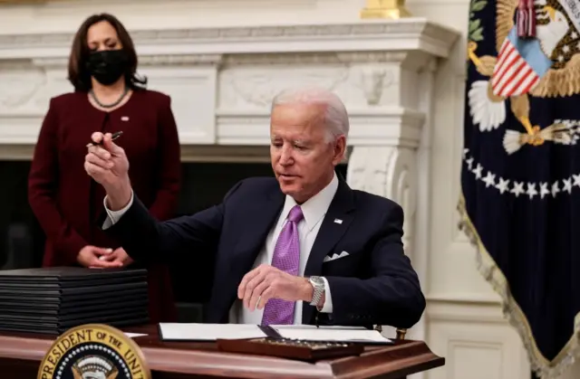 Joe Biden signs an executive order as part of his administration's Covid response