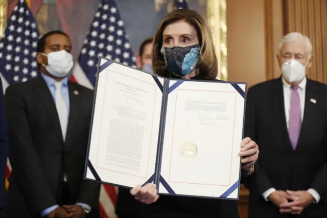 Speaker of the House Nancy Pelosi holds the signed Article of Impeachment against US President Donald Trump