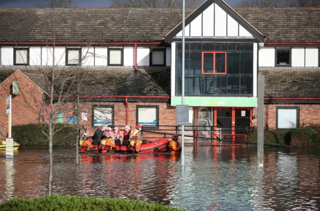 Firefighters transporting people in dinghy