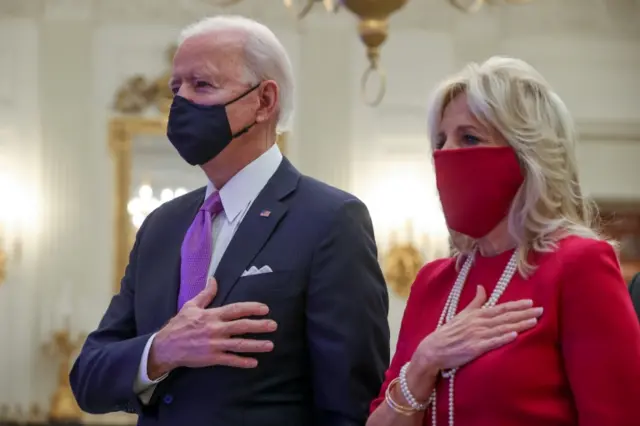 President Joe Biden and first lady Jill Biden stand for the national anthem sung by Patti LaBelle