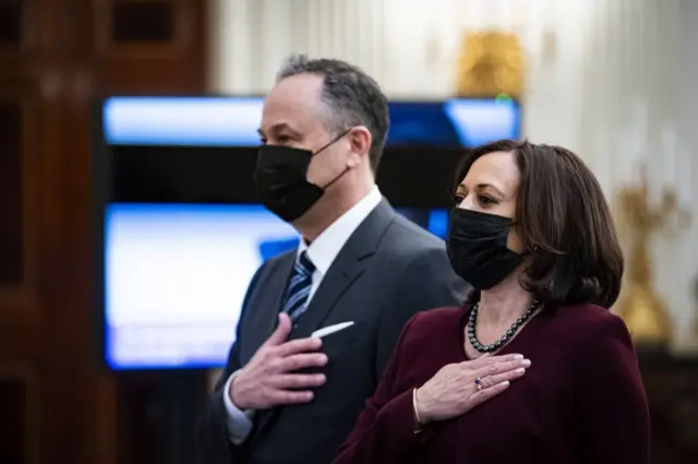 Vice-President Kamala Harris and her husband Doug Emhoff, place their hands over their hearts as Patti LaBelle sings the National Anthem