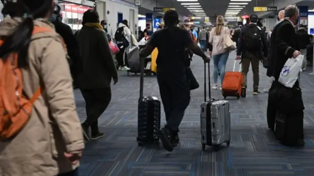 Passengers walk through a terminal at Dulles International airport in Dulles, Virginia,  amid the Coronavirus pandemic