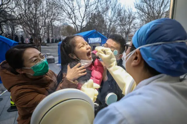 A medical worker collects nucleic acid samples at a testing site in Xicheng District