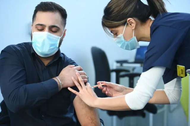 A nurse administers the Covid vaccine into a patient's arm