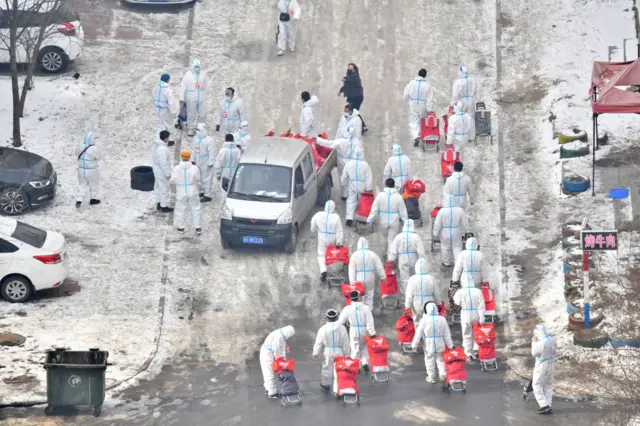 Volunteers in protective suits deliver daily necessities to residents at Dongchang District during the COVID-19 pandemic on January 25, 2021 in Tonghua, Jilin Province of China