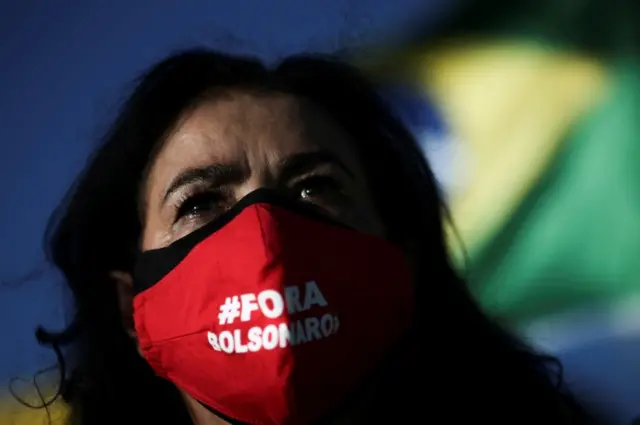 A demonstrator wearing a face mask reading "Out Bolsonaro" takes part in a protest against Brazil"s President Jair Bolsonaro and his handling of the coronavirus disease (COVID-19) outbreak in Brasilia, Brazil, on 24 January 2021