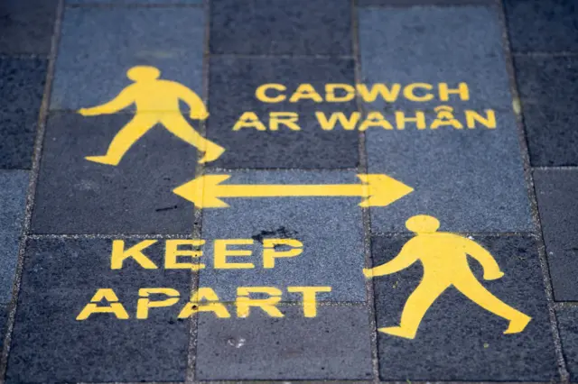 Social distancing sign in English and Welsh