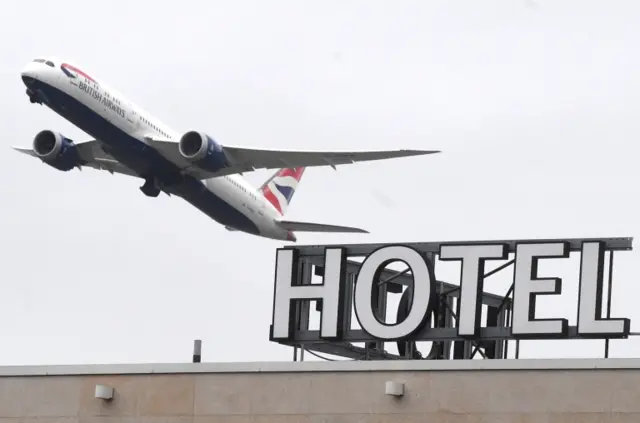 A plane flies over a hotel near Heathrow Airport