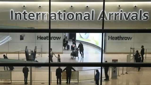 Travellers in the international arrival area of Heathrow Airport, near London