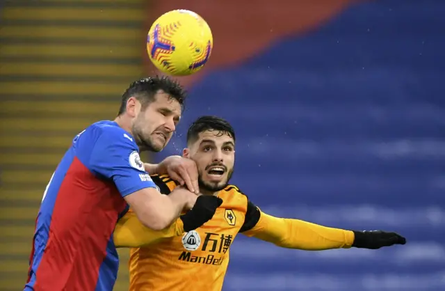 Scott Dann goes for a header with Pedro Neto