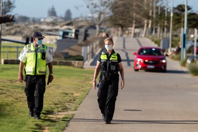 Police patrol Scarborough Beach in Perth just after a lockdown came into effect in the city