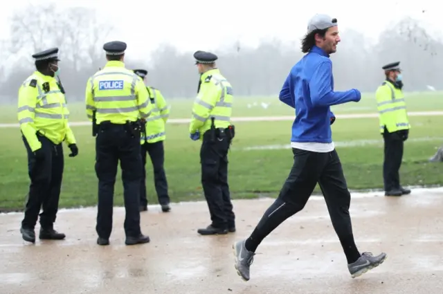 Man runs past police officers in Hyde Park, London