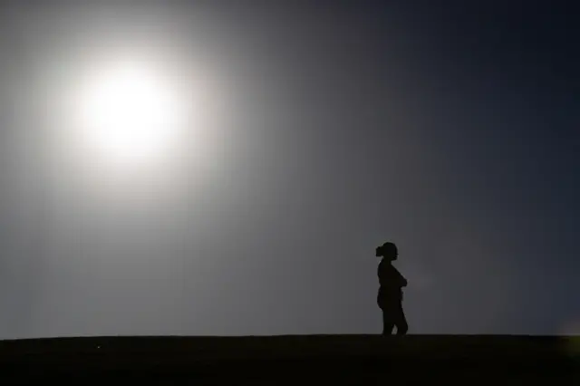 A woman looks out over Scarborough Beach as a lockdown comes into effect in Perth