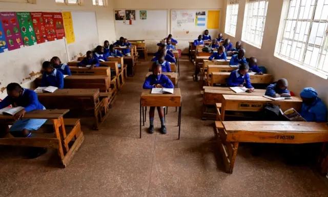 Students wearing masks sit in a classroom in Kenya