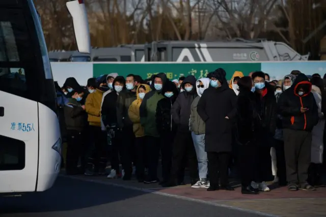 People wait to board shuttle buses to a COVID-19 coronavirus vaccine centre in Beijing