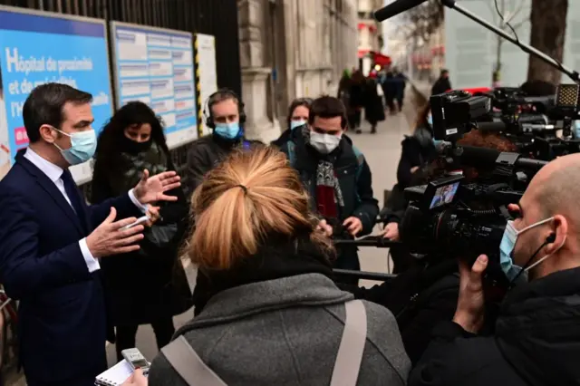 French Health Minister Olivier Veran (L) speaks to the press