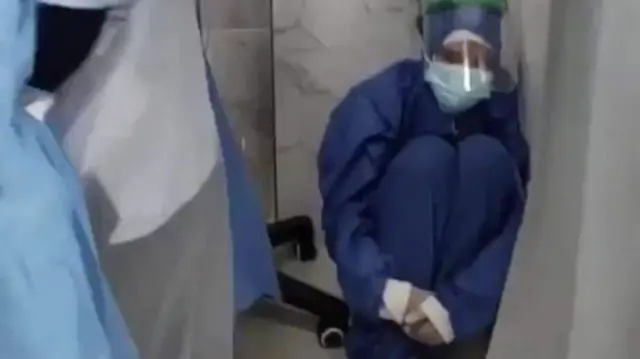 Screengrab of video purportedly showing an Egyptian nurse wearing PPE huddled next to a hospital bed