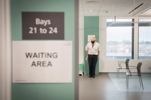 Boris Johnson in the waiting area during a visit to view the vaccination programme at Chase Farm Hospital in north London