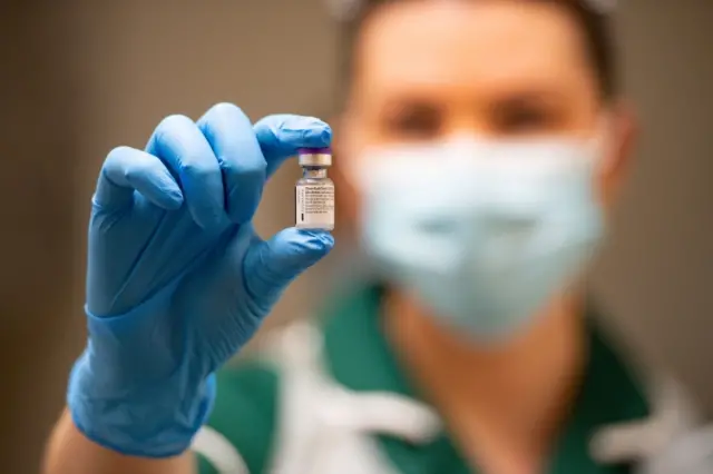 A nurse holds a phial of the Pfizer-BioNTech vaccine (file photo)