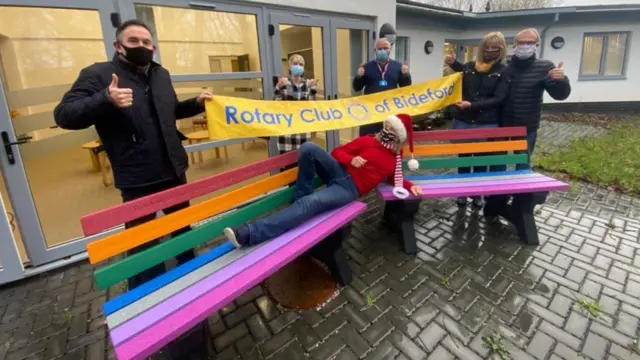 Rotary Club of Bideford members and NHS staff by two rainbow benches