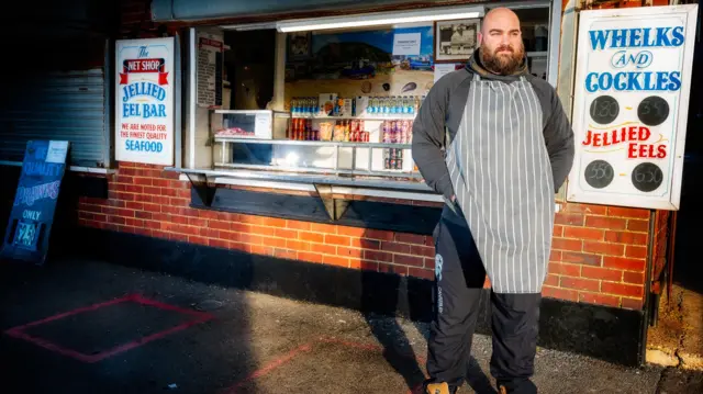 A man stands outside his jellied eel bar