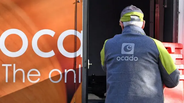 Supermarket delivery van filled by worker