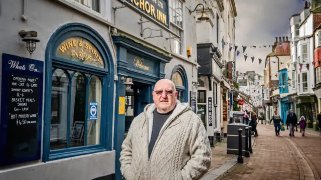 A man stands outside the Anchor Inn in Hastings