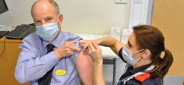 Dr Ian Currie receiving a vaccine