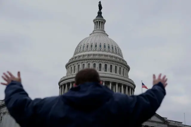 A Trump supporter gestures toward Congress