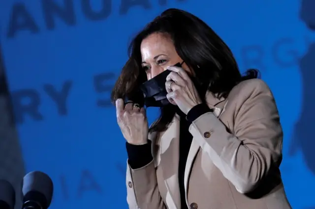 Kamala Harris removes her face mask as she campaigns for Democratic U.S. Senate candidates Jon Ossoff and Raphael Warnock at an outdoor campaign event ahead of U.S. Senate runoff elections in Savannah, Georgia, U.S., January 3, 2021.