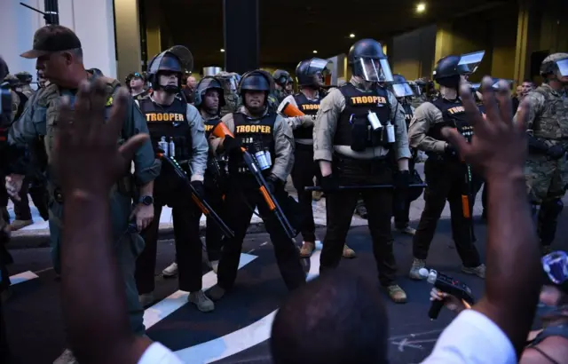 upporters of "Black Lives Matter" hold their hands up in front of a line of State troopers and National Guards in Tulsa, Oklahoma