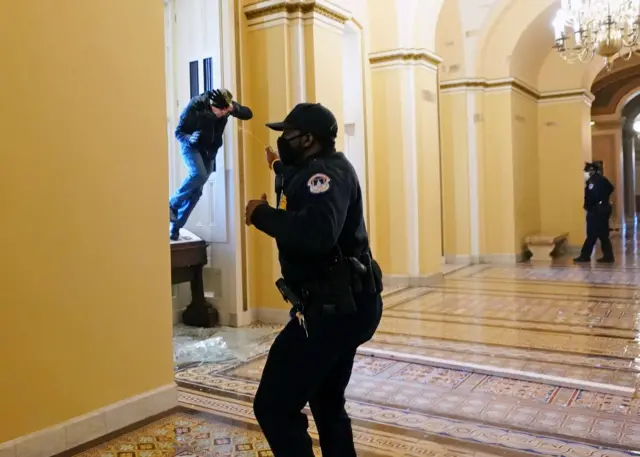 Capitol police officer shoots pepper spray at a protestor attempting to enter the Capitol building during a joint session of Congress to certify the 2020 election results on Capitol Hill in