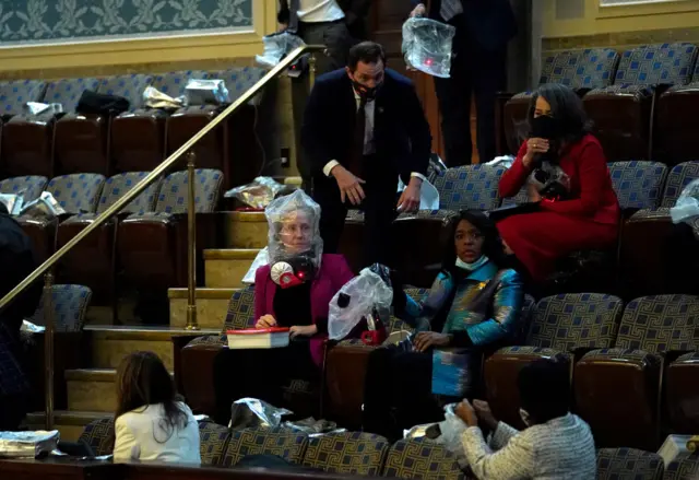 People wear plastic bags s protesters attempt to enter the House Chamber during a joint session of Congress on January 06, 2021 in Washington, DC