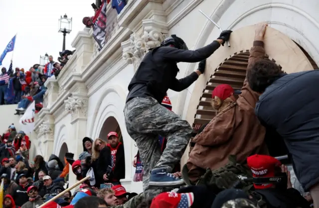 Pro-Trump protesters scale a wall as they storm the U.S. Capitol Building, during clashes with Capitol police at a rally to contest the certification of the 2020 U.S. presidential election results by the U.S. Congress, in Washington, U.S, January 6, 2021.