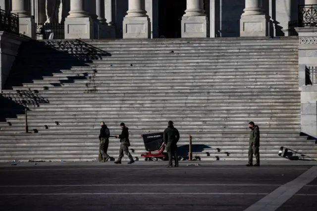 Police survey damage and debris at the US capitol