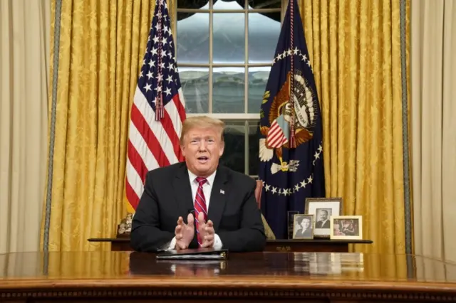 President Trump sits at his desk in the Oval Office