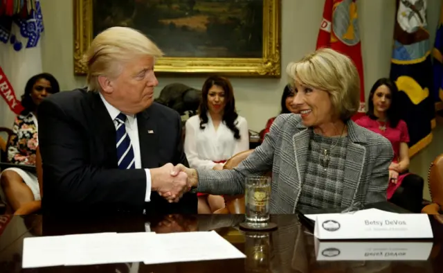 U.S. President Donald Trump congratulates his Secretary of Education Betsy DeVos on her confirmation in 2017