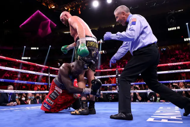 Deontay Wilder drops to his knees after a punch from Tyson Fury
