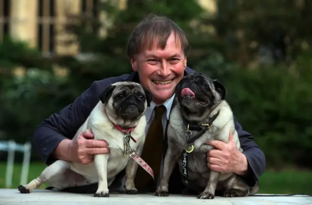 Sir David Amess with pug dogs in 2013