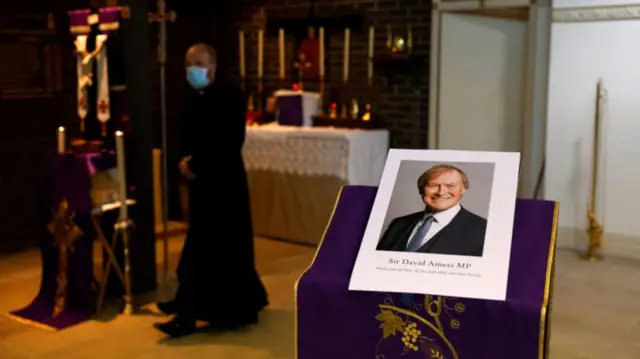 A picture of Sir David Amess on a pedestal at a church