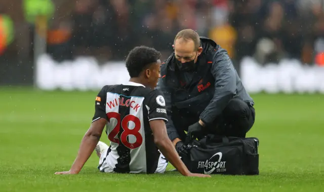 Joe Willock is attended to by a Newcastle physio