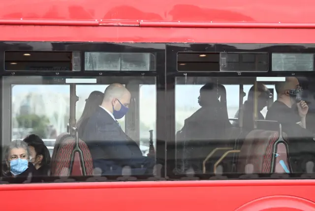 Passengers wear face masks whilst travelling on a bus in London