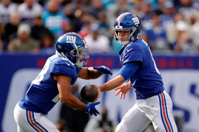 Devontae Booker takes the ball from Daniel Jones