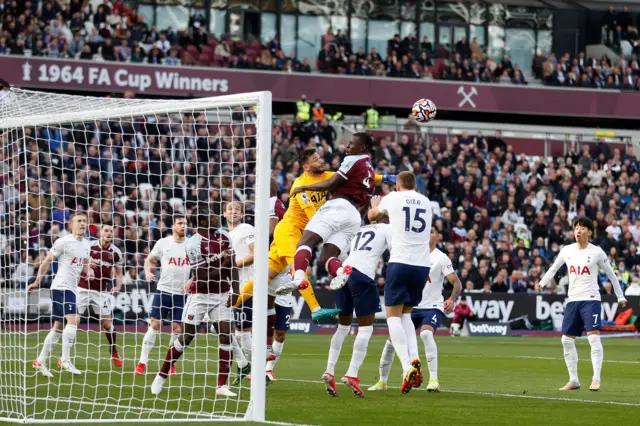 Tottenham Hotspur's French goalkeeper Hugo Lloris (CL) punches the ball ahead of West Ham United's French defender Kurt Zouma (CR) during the English Premier League football match between West Ham United and Tottenham Hotspur