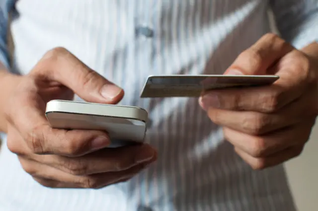 Man using phone and credit card