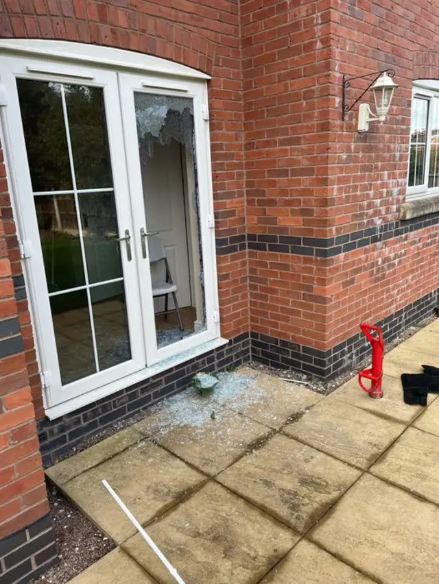 A broken patio door after police raid