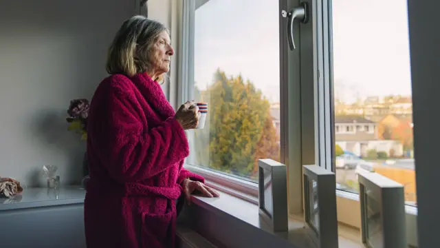 Pensioner looking out of window