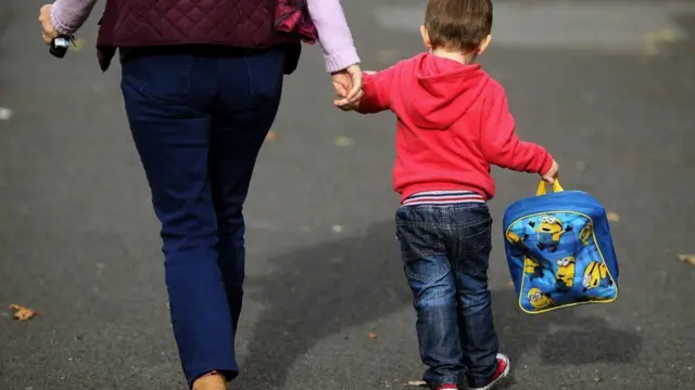 A stock photo of a woman walking with a child